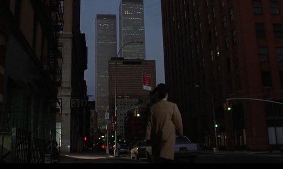 An screenshot of the movie American Psycho, as a person walks through new york as the sun suts.